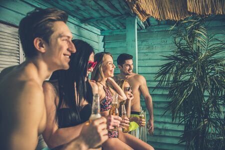 Group of five friends celebrating in their summer beach houseの写真素材