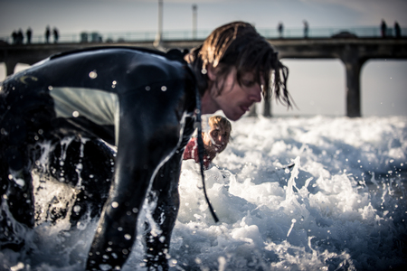 Three surfers practicing in the oceanの写真素材