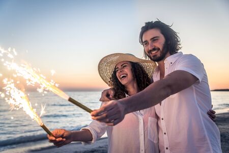 Couple strolling at the beach and smiling - Young adults enjoying summer holidays on a tropical islandの写真素材