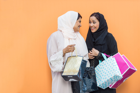 Arabic women shopping outdoors in Dubai - Girls with traditional arabian dress having funの写真素材
