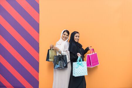 Arabic women shopping outdoors in Dubai - Girls with traditional arabian dress having funの写真素材
