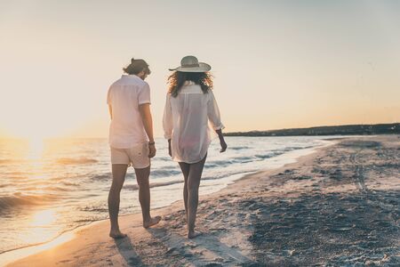 Couple strolling at the beach and smiling - Young adults enjoying summer holidays on a tropical islandの写真素材