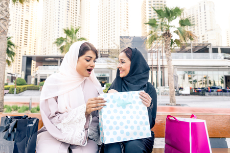Arabic women shopping outdoors in Dubai - Girls with traditional arabian dress having funの写真素材
