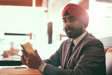 Indian businessman in a cafe taking a coffeeの写真素材