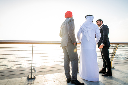 Multiethnic business team meeting outdoors - Three businessmen talking about business on a formal meetingの写真素材