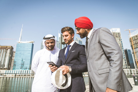 Multiethnic business team meeting outdoors - Three businessmen talking about business on a formal meetingの写真素材