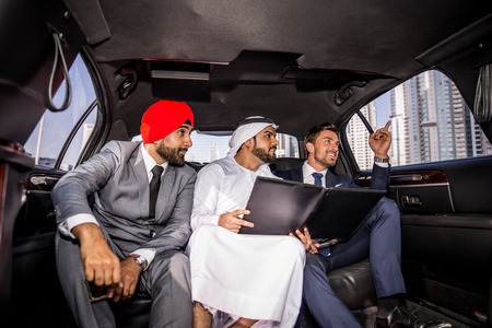 Multiethnic business team meeting outdoors - Three businessmen talking about business on a formal...