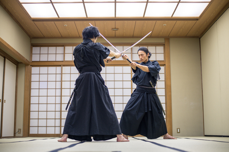 Japanese martial arts athlete training kendo in a dojo - Samaurai practicing in a gym