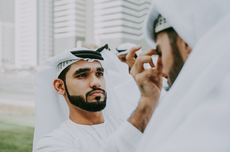 Group of businessmen talking on the street in Dubaiの写真素材