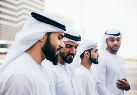 Group of businessmen talking on the street in Dubaiの写真素材