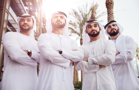 Group of businessmen talking on the street in Dubaiの写真素材