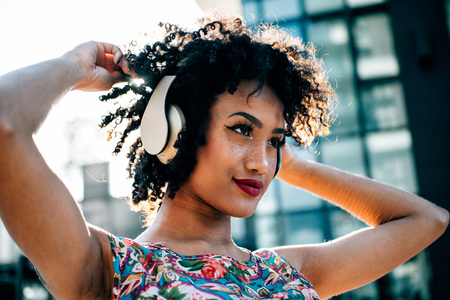 Beautiful latin woman with curly hair, portrait set in the cityの写真素材
