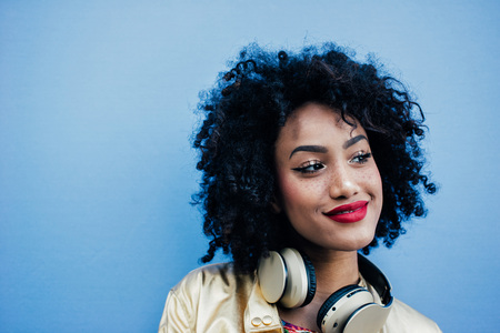 Beautiful latin woman with curly hair, portrait set in the city