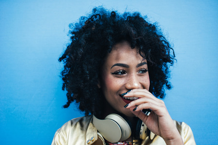 Beautiful latin woman with curly hair, portrait set in the cityの写真素材