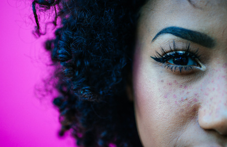 Beautiful latin woman with curly hair, portrait set in the cityの写真素材