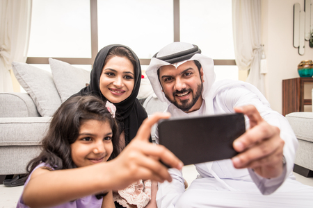 Happy arabian family having fun at homeの写真素材