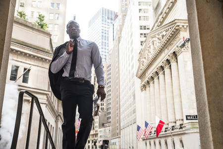 Businessman in full suit walking in Wall Street, New Yorkの写真素材