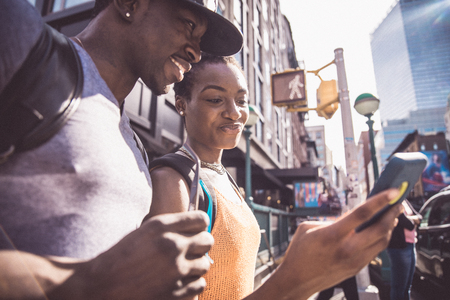 Couple of lovers in New York looking at smart phoneの写真素材