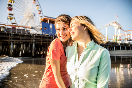 Lesbian couple playing and dating on the beachの写真素材