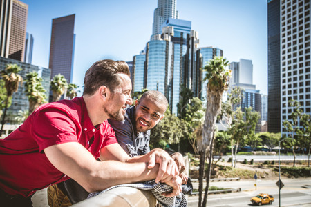 Homosexual couple at a romantic date outdoors - Multi-ethnic gay couple in love flirting and having funの写真素材