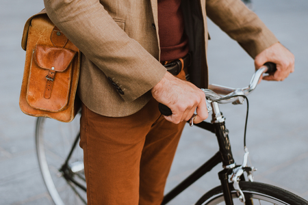 Handsome young business man with his modern bicycle.の写真素材