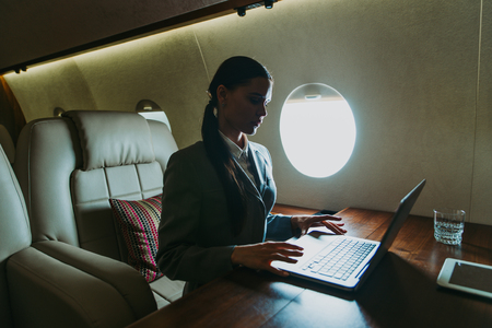 Business woman traveling and working on the private jetの写真素材