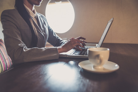 Business woman traveling and working on the private jet