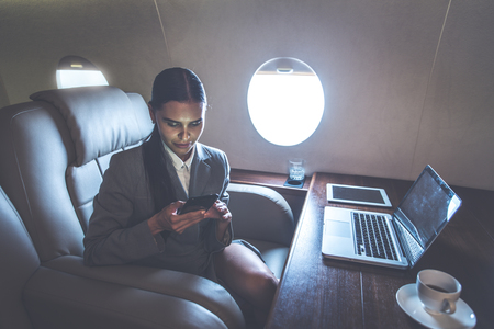 Business woman traveling and working on the private jetの写真素材