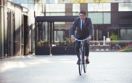 handsome young business man with his modern bicycle.の写真素材