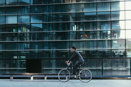 Handsome young business man with his modern bicycle.