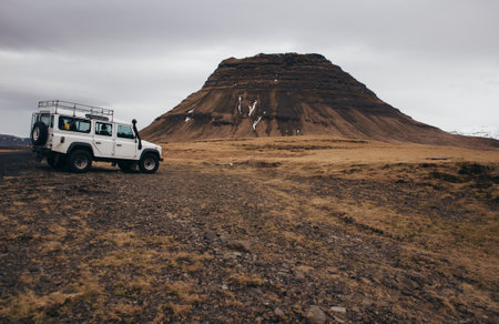 ICELAND, KIRKJUFELL, 16TH APRIL 2018. The land Rover defender parked in front the kirkjufell. The Defender  is a four-wheel drive off-road vehicle developed in the 1980sのeditorial素材