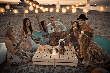 Group of friends having a picnic at the beach - Happy young people on a summer vacation at the beachの写真素材