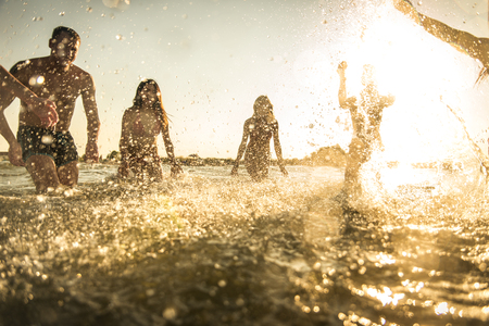 Group of friends having fun at the sea - Happy young people on a summer vacation at the beachの写真素材