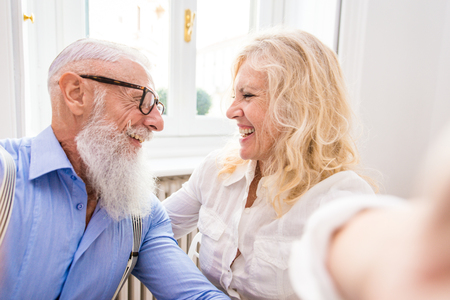 Happy senior couple having breakfast at home - Married couple on the 60's in their apartment, concepts about seniority and relationshipの写真素材