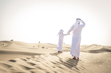 Happy family playing in the desert of Dubai -  Playful father and his son having fun outdoorsの写真素材