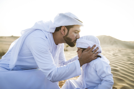 Happy family playing in the desert of Dubai -  Playful father and his son having fun outdoorsの写真素材