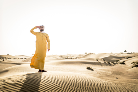 Handsome arabian man with traditional dress in the desert of Dubaiの写真素材
