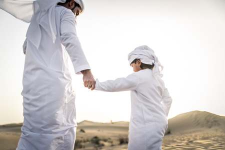 Happy family playing in the desert of Dubai -  Playful father and his son having fun outdoorsの写真素材
