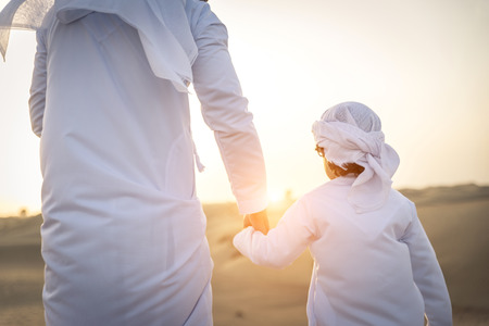 Happy family playing in the desert of Dubai -  Playful father and his son having fun outdoors