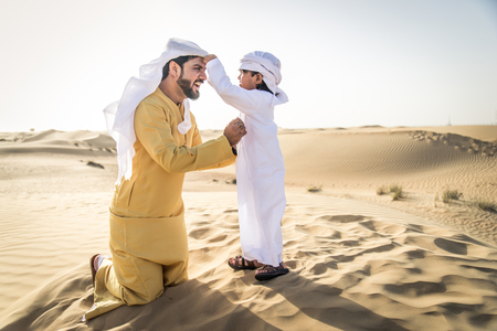 Happy family playing in the desert of Dubai -  Playful father and his son having fun outdoorsの写真素材