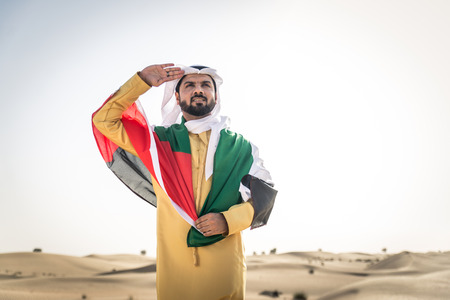 Handsome arabian man with traditional dress in the desert of Dubaiの写真素材