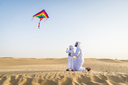 Happy family playing in the desert of Dubai -  Playful father and his son having fun outdoorsの写真素材