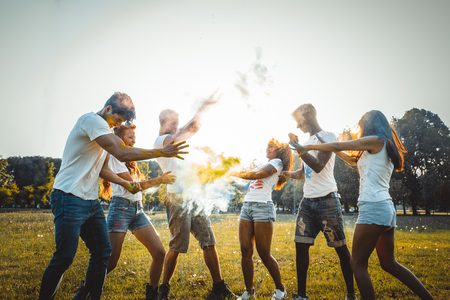 Group of happy friends playing with holi colors in a park - Young adults having fun at a holi festival, concepts about fun, fun and young generationの写真素材