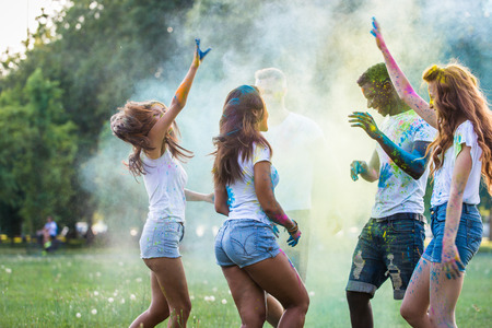 Group of happy friends playing with holi colors in a park - Young adults having fun at a holi festival, concepts about fun, fun and young generationの写真素材
