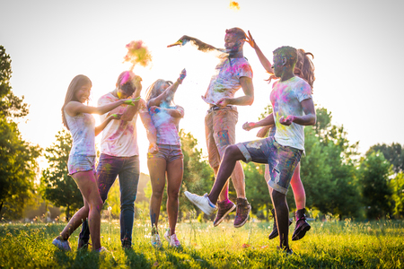 Group of happy friends playing with holi colors in a park - Young adults having fun at a holi festival, concepts about fun, fun and young generationの写真素材