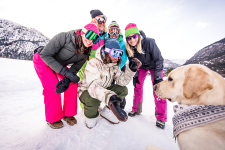 Happy group of people having fun on winter vacation - Friends with snow suit partying outdoorsの写真素材