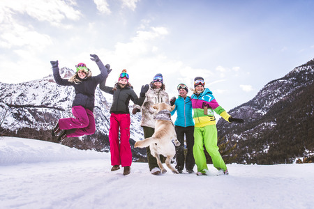 Happy group of people having fun on winter vacation - Friends with snow suit partying outdoorsの写真素材