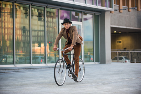 Young handsome man with casual clothes driving bycicle - Young student portrait, concepts about business, mobility and lifestyleの写真素材