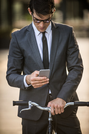 Young handsome man with business suit driving bycicle - Corporate businessman portrait, concepts about business, mobility and lifestyleの写真素材