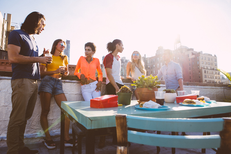Group of friends spending time together on a rooftop in New York city, lifestyle concept with happy peopleの写真素材